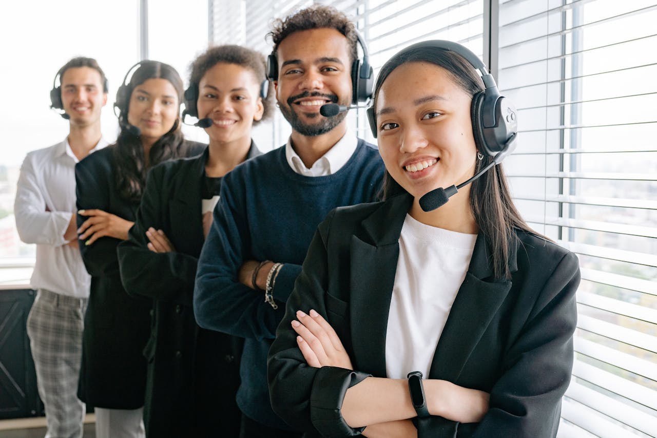 who-we-are A diverse group of smiling call center agents in an office setting.