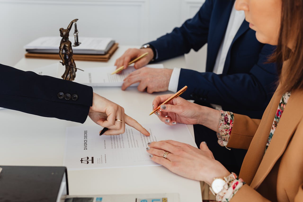 embark Hands signing a divorce decree, with a justice statue nearby, symbolizing legal proceedings.